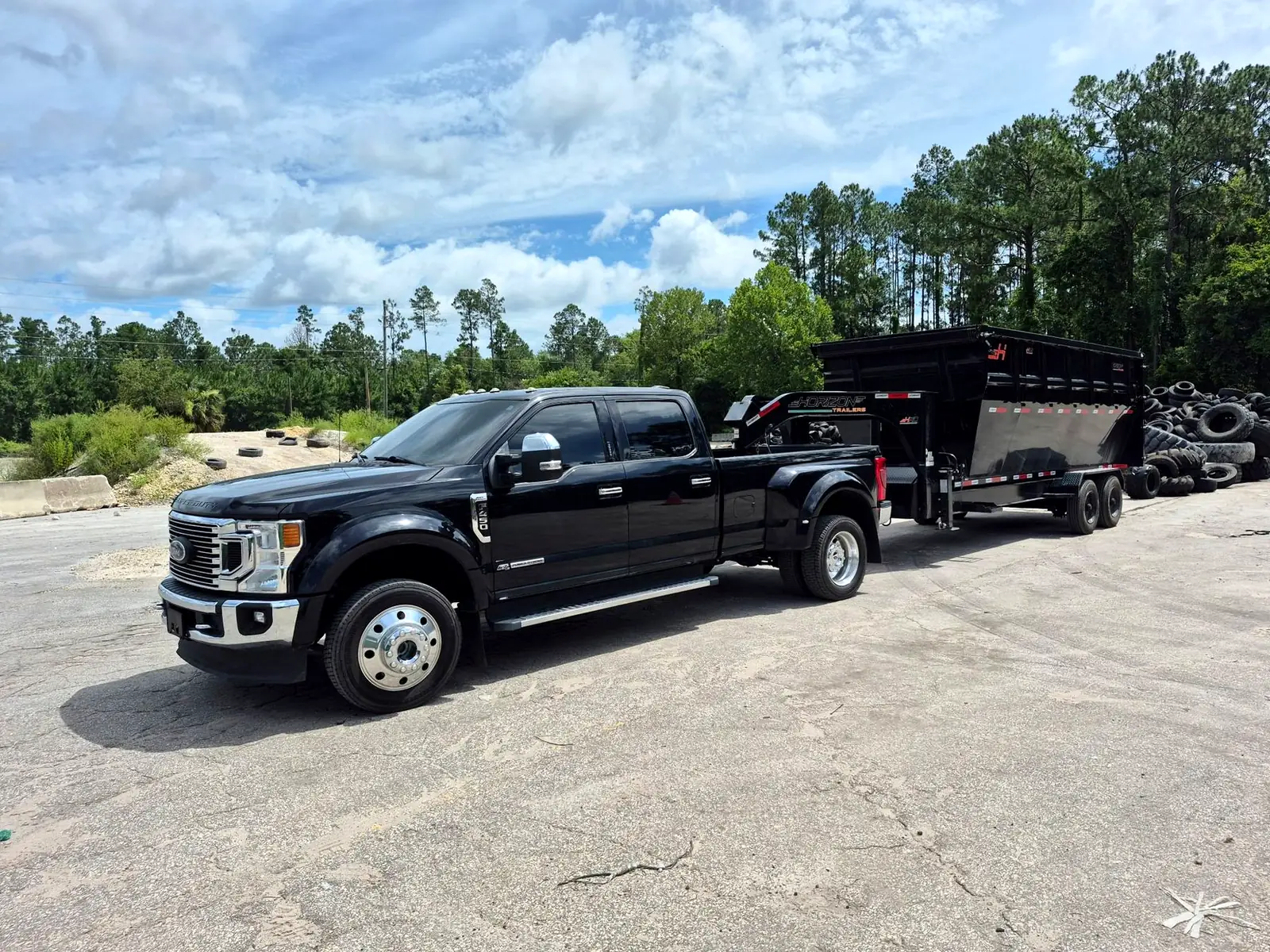 A1A truck with roll-off tire dumpster trailer