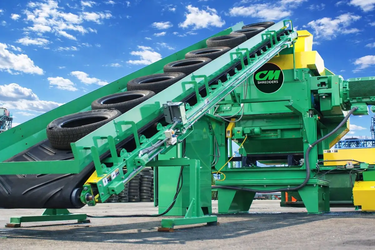 Passenger tires on the infeed conveyor of a CM tire shredder